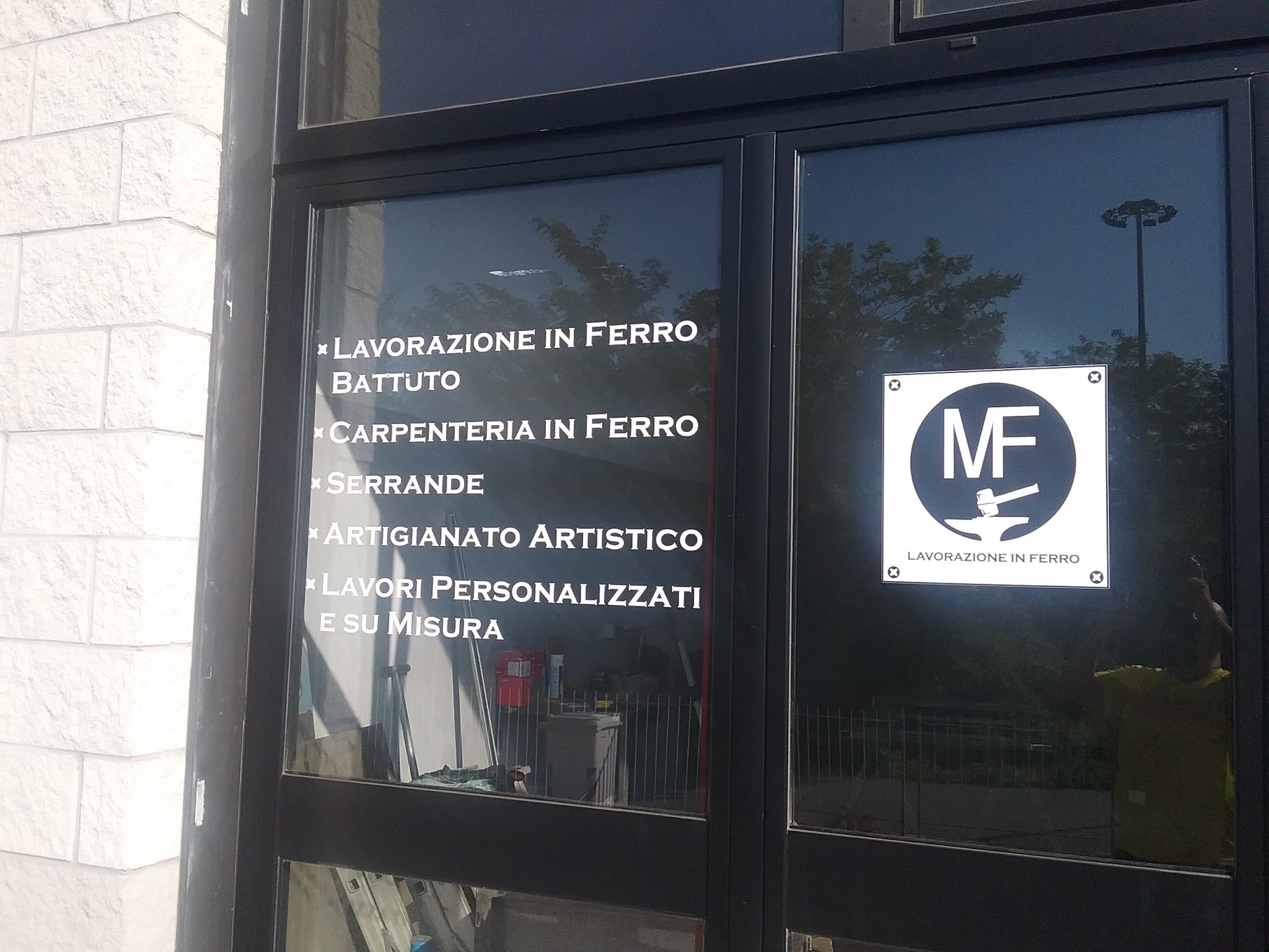 Logo MF e lista delle lavorazioni sulla vetrina