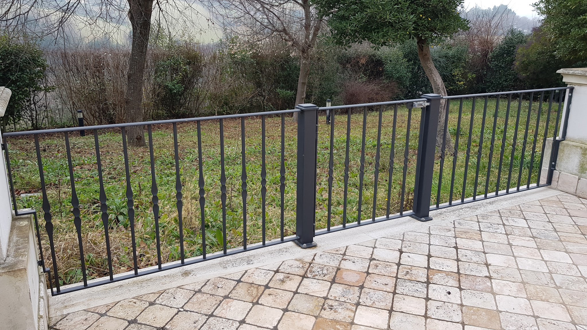 Cancello e ringhiera in metallo installati in un giardino